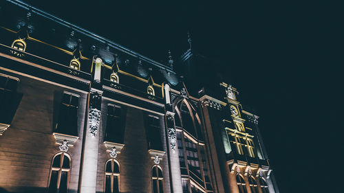 Low angle view of illuminated building against sky at night