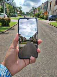 Close-up of person holding camera on road