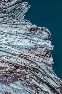 Close-up of rock formation in sea against clear blue sky