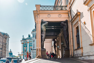 Low angle view of people on street amidst buildings in city