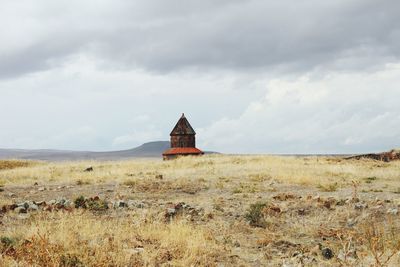 Building on field against sky