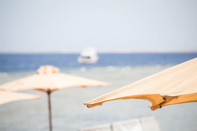 Close-up of umbrella on beach against clear sky