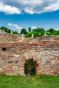 Stone wall on field against sky