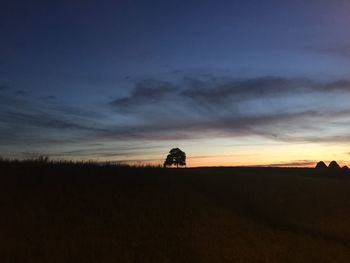 Silhouette field against sky during sunset