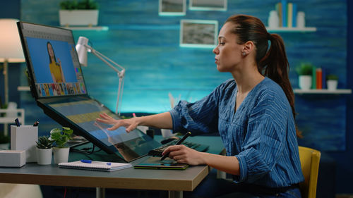 Young woman using mobile phone on table