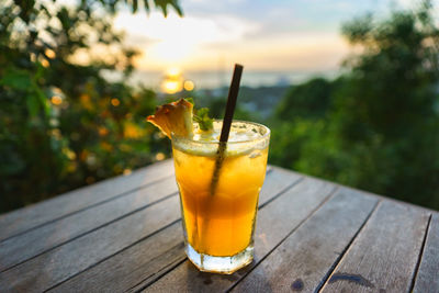 Close-up of drink on table during sunset