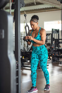 Sporty woman exercising pulley in studio. for arm and shoulder muscles. 