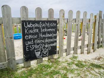 Information sign on field by fence