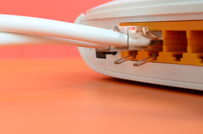 Close-up of network plugs connected to equipment on orange background