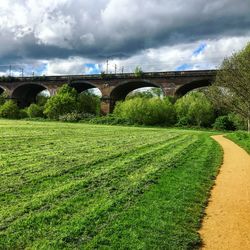 Arch bridge over land against sky