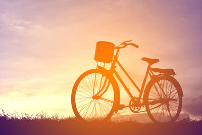 Silhouette wheel against sky during sunset