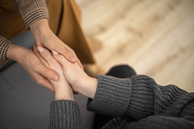 Low section of woman holding hands