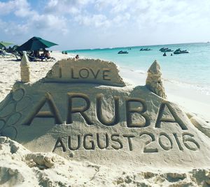 Text on beach against sky