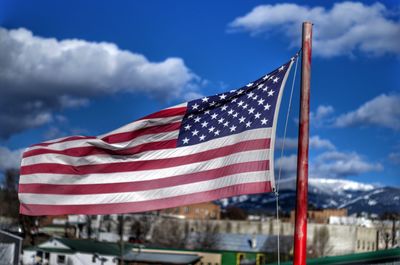 Close-up of american flag waving against blue sky during sunny day