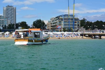 Boats in sea against buildings in city
