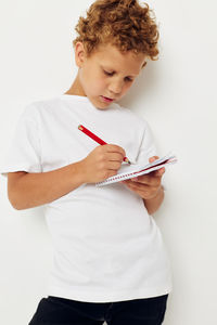 Young woman using digital tablet while standing against white background