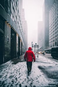 Man with umbrella on snow in city