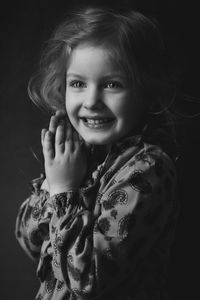 Portrait of smiling woman against black background