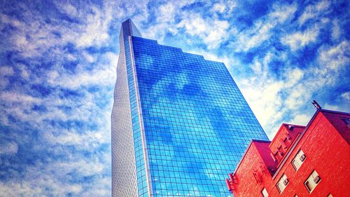 Low angle view of modern building against cloudy sky