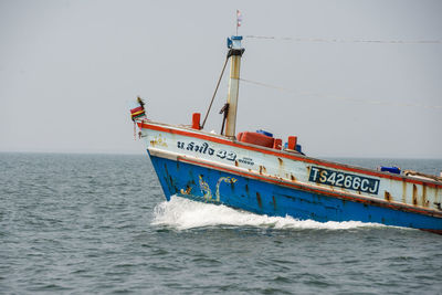 Ship sailing on sea against clear sky