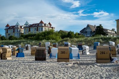 Deck chairs on beach against sky