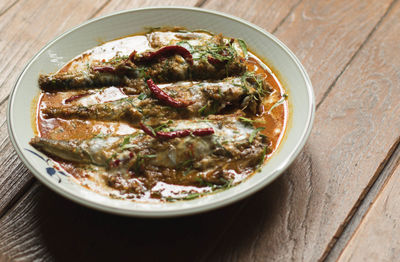 Rustic cooked food in a white plate on wooden table