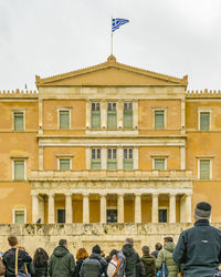 Group of people in front of building against sky