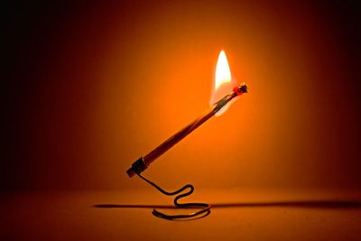 Close-up of lit candle on table