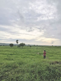 Man standing on field against sky