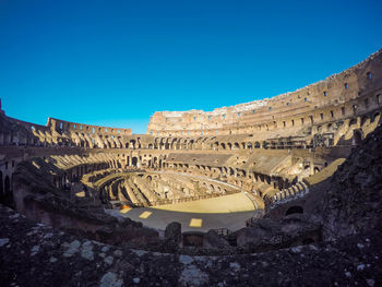 Low angle view of old ruins against clear blue sky