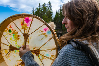 Side view portrait of young woman holding umbrella