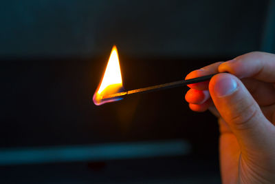 Hand with burning match on black