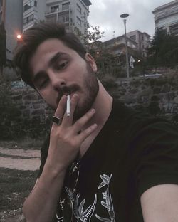 Man smoking cigarette in city
