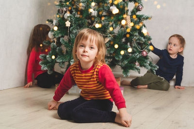 Children waiting for christmas at home near the christmas tree. 