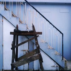 Abandoned metal railing on staircase against wall