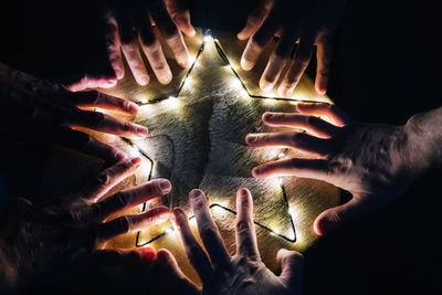 Cropped hands by illuminated star shape