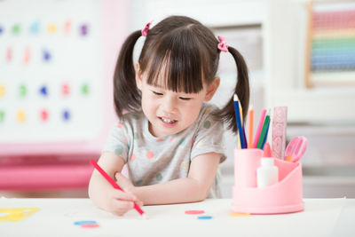 Portrait of cute girl sitting on table