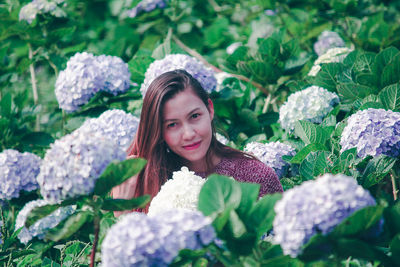 Portrait of woman with pink flowers in garden