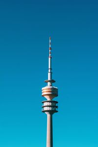 Low angle view of communications tower against blue sky