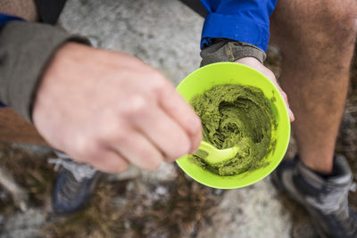 High angle view of hiker stirring bowl of guacamole.