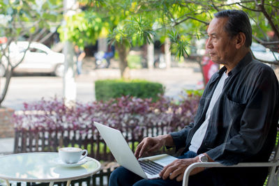 Man using laptop while sitting by table at caf�