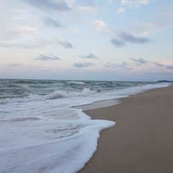 Scenic view of beach against pink sky