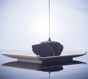 Close-up of electric lamp hanging on table against wall