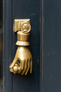 Golden hand holding a door knob a a door knocker in london