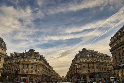 Low angle view of buildings against cloudy sky