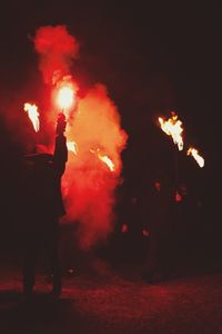 Silhouette man with fire crackers at night