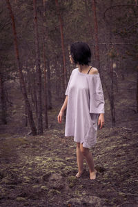 Rear view of woman standing in forest