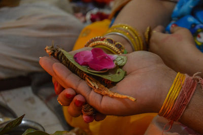 Close-up of woman holding red rose in hand