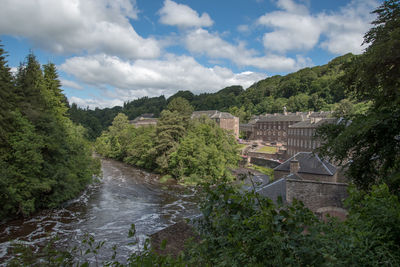Scenic view of river amidst trees against sky