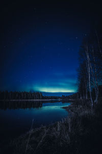 Scenic view of lake against sky at night